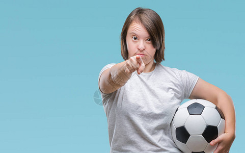 患有唐氏综合症的年轻成年女在孤立的背景下拿着足球图片