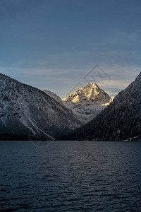 冬天在普兰西湖点燃的雪山比勒尔山峰图片