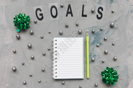 灰色和蓝色背景上的目标词记事本和绿色笔图片