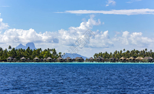 豪华水上茅草屋顶平房度假村位于法属波利尼西亚波拉岛清澈蓝色泻湖图片