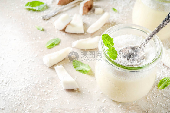 纯素甜食玻璃罐装椰子奶冻甜点椰子片和薄荷叶浅色混凝土石图片