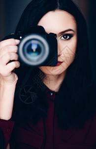 年轻女子用单反相机拍照的肖像女摄影师图片