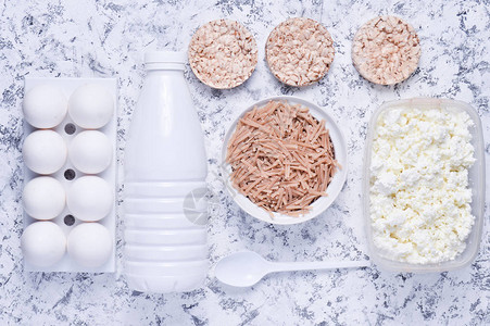饮食健康食品的顶视图酥脆的圆形饮食健身面包小屋奶酪酸奶瓶荞麦面白色混凝土背景上的塑图片