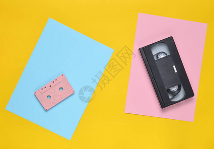 彩色纸背景上的录音带和录像带80年代的复古娱乐技术顶视图极简主图片