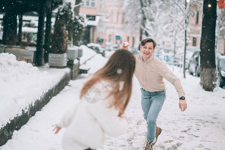 欢乐的年轻夫妇在街上玩雪球图片