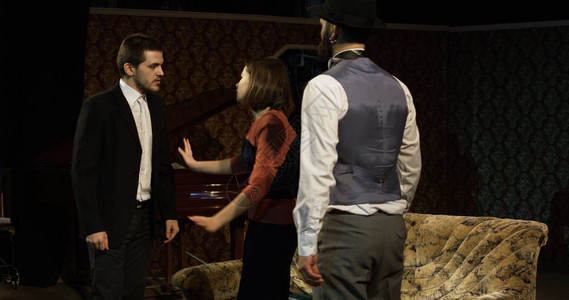 中区演员在两个争吵的男子之间进行妇女调解的场图片