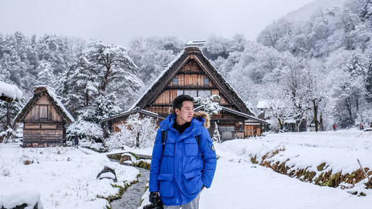 摄影师在冬季下雪时在白川乡地区拍照图片