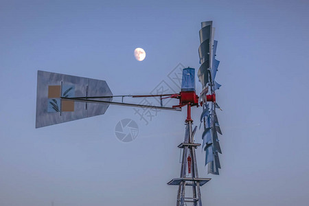 在犹他谷风车后面的天空中近距离观察风车和月亮图片