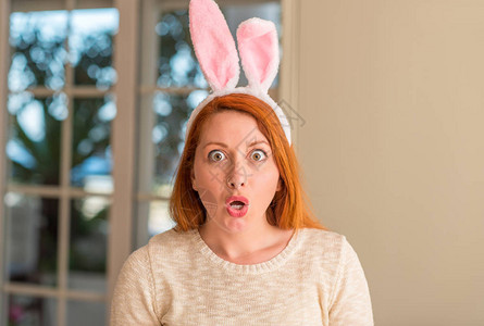 红头妇女在家里穿着复活节兔子耳朵图片