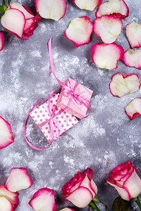 情人节背景框架与玫瑰鲜花束和石背景上的礼品盒顶视图图片