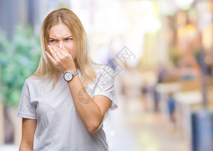 年轻的白种女人在与世隔绝的背景下闻到某种臭味和恶心难以忍受的气味图片