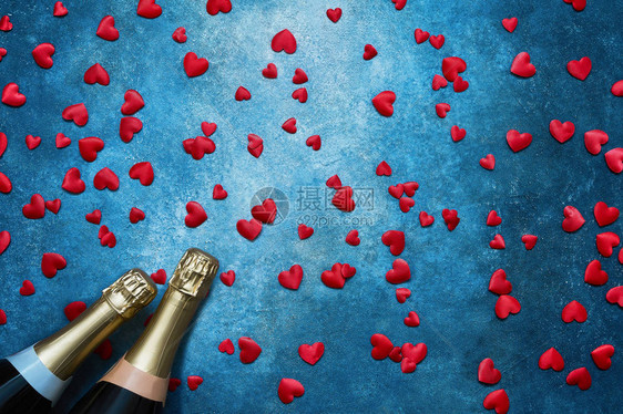 情人节背景蓝色背景上有红心的两个香槟瓶复制空间图片
