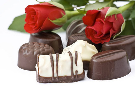 白色背景上的巧克力和玫瑰背景图片