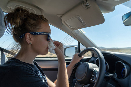 女司机开车时用纸巾擤鼻涕分心驾驶多任务健康问题感冒生病医图片