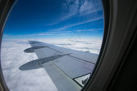 从飞机的窗户可以看到蓝天白云的福克100型号的机翼和发动图片