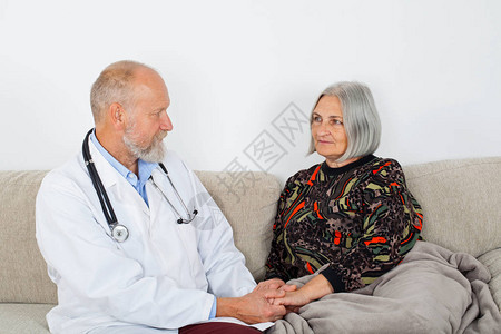 老年男医生检查坐在沙发上的老年妇女图片