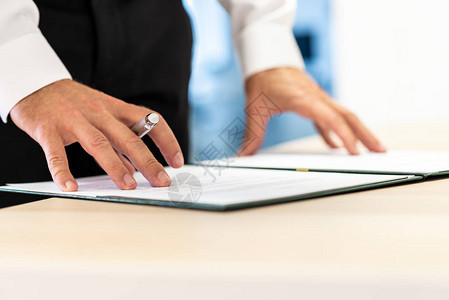 企业执行官在签署之前先在一个文件夹中审查重要文件或合同图片
