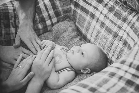 手放在婴儿上刚出生的婴儿躺在扶手椅上母亲和父亲节的概念家庭图片