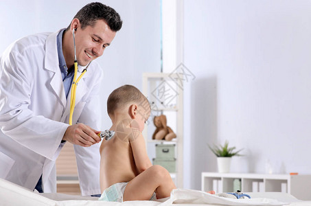 儿童医生在医院用听诊器检查小男孩并进行图片