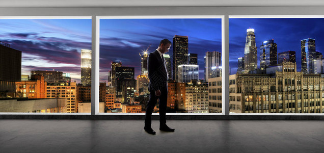 中年商人在洛杉矶市寻找一个明亮的办公窗户和思维图片