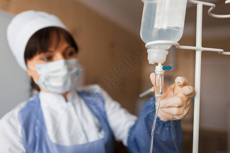 医院病房的护士检查柜台滴一位女医生在手术后照顾病人清图片