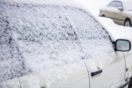 冬季城市道路漂流雪中的汽图片