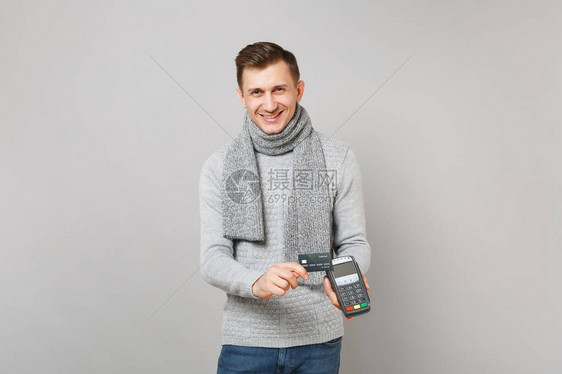 微笑的男子手持无线现代银行支付终端进行处理图片