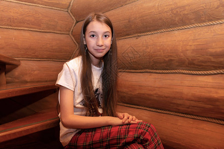 一个长着头发的欧裔女孩坐在木质楼梯上图片