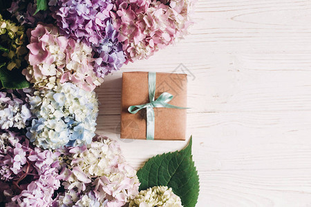 美丽的绣球花和质朴的白木上的礼盒图片