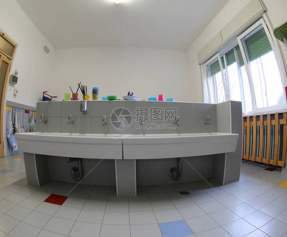 学校浴室内有大型陶瓷池的厕所图片