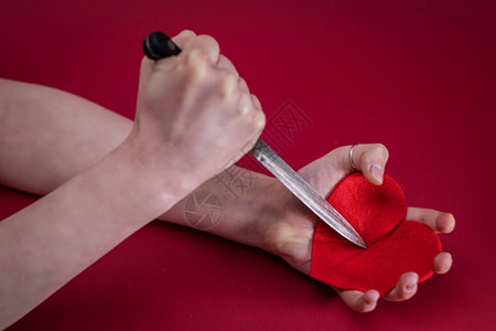 用刀刺入红心意思是摧毁我的心脏图片素材