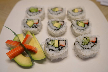 盘子上的鳄梨和螃蟹寿司部分图片