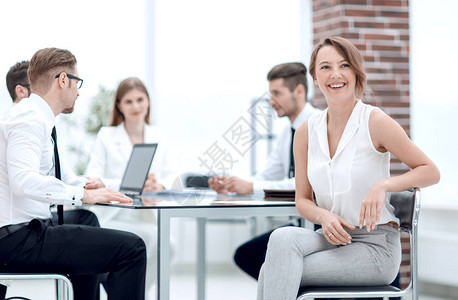 坐在服务台的微笑着的雇员和企业团队团队图片