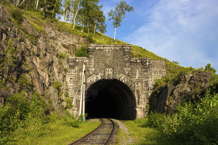 环贝加尔湖铁路山上的石拱隧道在神秘的西伯利亚旅行的夏季景观贝加尔湖海岸线上的跨西伯利亚铁路采矿工程背景