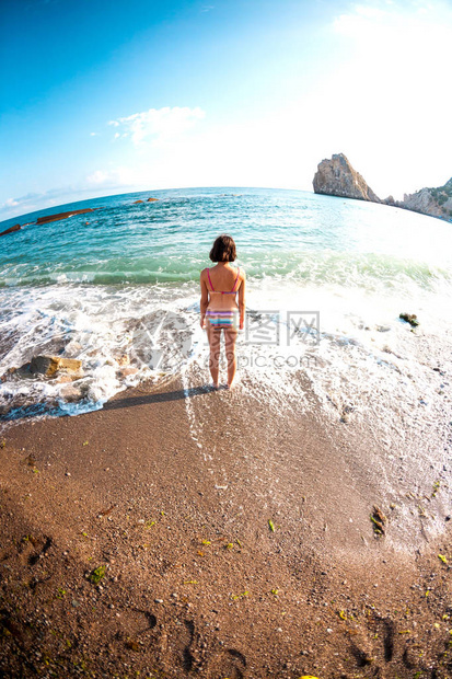 女孩进入海水女人在海里洗澡在海岸休息泳装的苗条图片