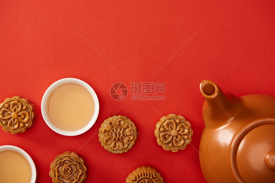 用红色隔开的传统月饼茶壶和杯子的顶视图图片