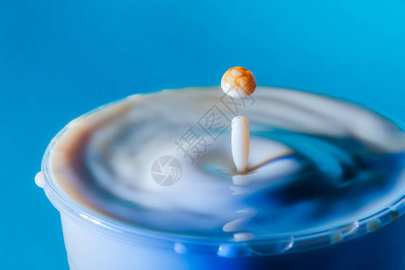 摄影棚蓝色背景的焦糖牛奶滴出的照片图片
