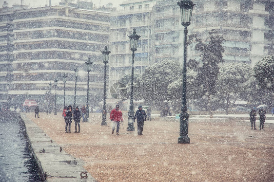 人们在城市中心的雪中行走在图片