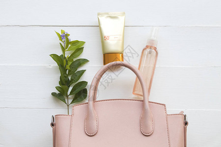 自然化妆品防晒霜水喷水的保健护理皮肤脸部和粉红色的生活方式妇女手袋图片