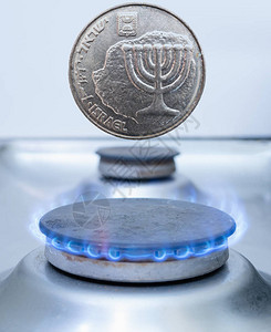 一枚以色列谢克尔硬币盖在煤气炉上以色列概念中的生产工业出口或图片