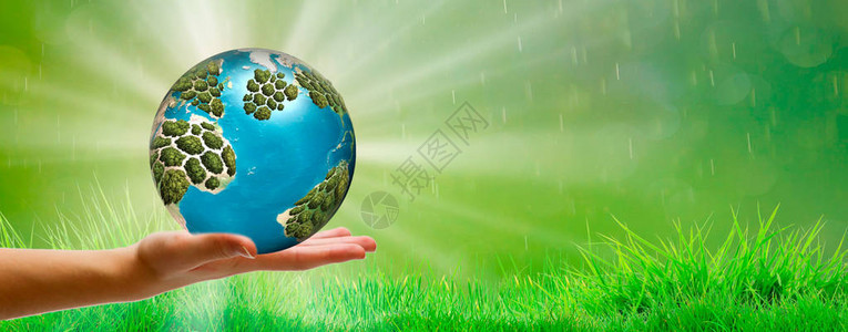 人类在绿色春季背景和太阳光照耀下将地球掌握在手图片
