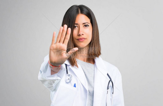 有听诊器的女医生手举停止手势否认一种在灰色背景上认图片