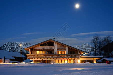 雪冬月光下的传统乡村木屋背景图片