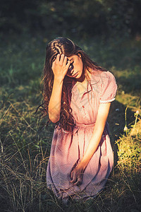 年轻女孩穿着古老的裙子坐在草地上图片