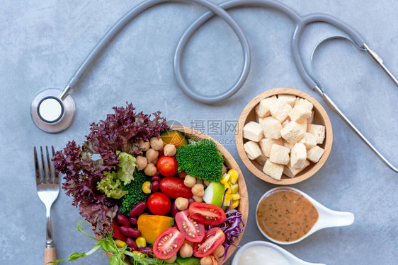 新鲜蔬菜沙拉和运动设备健康食品绷带MD医生的妇科医生听诊器图片