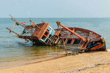 一艘破损的渔船靠岸倒在一边遭遇海难图片素材
