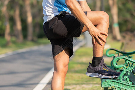 拿着他的运动腿受伤的年轻健身人训练时肌肉疼痛亚洲跑步者在早上跑步和锻炼后出现小腿疼痛和问题运图片