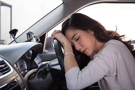 疲累的年轻妇女在车里睡觉图片