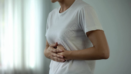 胃痛的妇女肚子疼患有胃肠图片