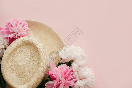 带有复制空间的春天图像暑假概念淡粉色纸上白色和粉色牡丹的草帽图片